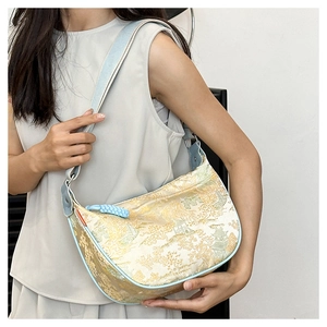Detailed shot of jacquard crescent bag with mountain scenery worn on shoulder