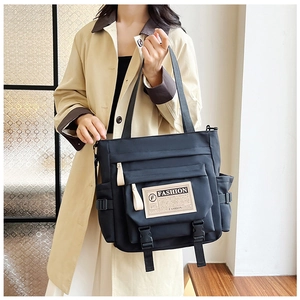 Dettaglio della borsa capiente in nylon con tasche multiple e etichetta alla moda