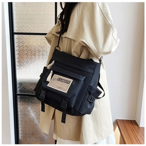 Dettaglio dell'etichetta moda e tasca con fibbia su borsa a tracolla in nylon nero