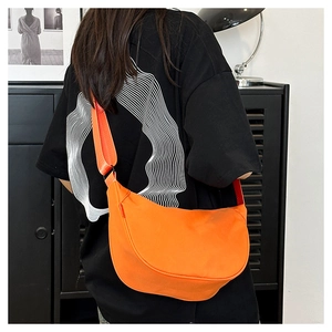 Detail of bright orange waterproof nylon dumpling bag with adjustable wide strap