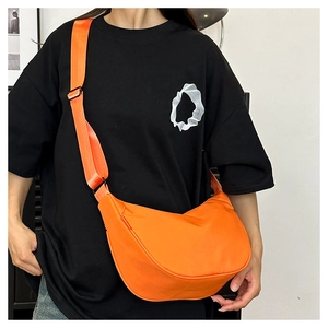 Detail of orange nylon crescent bag showing water-resistant fabric and adjustable wide strap