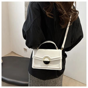 Detailed view of the white vintage crossbody bag featuring a unique circular metal clasp