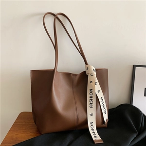 Sac cabas minimaliste en cuir marron mat avec ruban tendance sur table en bois