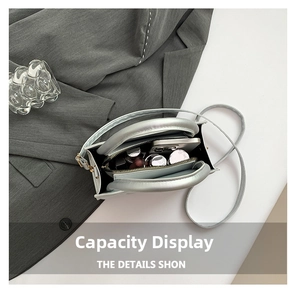 Flat lay of silver metallic handbag interior showing phone and cosmetics storage space