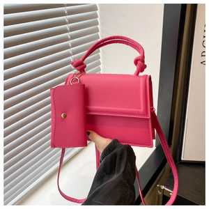 Détail du sac bandoulière rose avec poignée nouée et petit porte-monnaie assorti