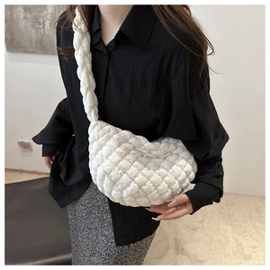 Détail de la texture du sac nuage blanc matelassé avec bandoulière tissée rembourrée