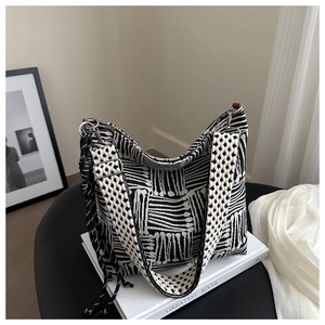 Close-up of minimalist black and white geometric patterned jacquard shoulder bag