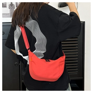 Rear view of a model wearing the large red canvas crescent crossbody bag for daily use