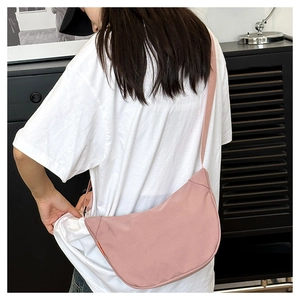 Model wearing a pink waterproof crescent crossbody bag showing size and fit on person