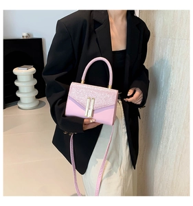 Detailed shot of pink glitter handbag flap with golden metallic buckle and leather texture