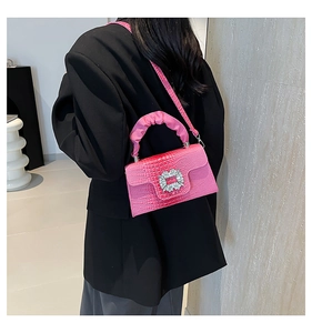 Detail of rose pink crocodile embossed crossbody bag with crystal buckle and ruched handle