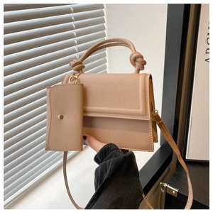 Détail du sac bandoulière en cuir PU beige avec poignée nouée et mini pochette assortie