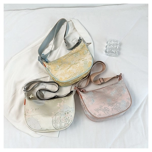 Detailed texture of silk jacquard crescent bags with traditional Chinese landscape patterns