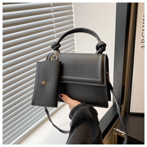 Détail du sac bandoulière noir avec poignée nouée et mini porte-monnaie amovible