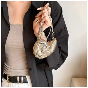 Detail of golden nautilus shell clutch bag with spiral metal texture and snake chain