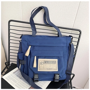 Dettaglio borsa a tracolla in nylon blu scuro con toppa fashion e fibbie regolabili