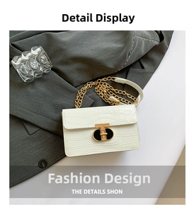 Detail shot of white crocodile texture faux leather bag with gold T-bar metal lock