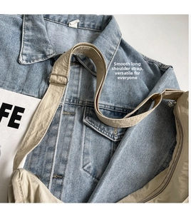 Détail de la bandoulière réglable et fermeture éclair sur sac besace en nylon beige
