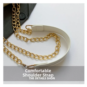 Detail of white crocodile skin shoulder strap with golden chain and padded leather
