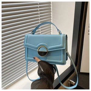 Detailed shot of sky blue crossbody bag with vintage leather texture and gold metal lock