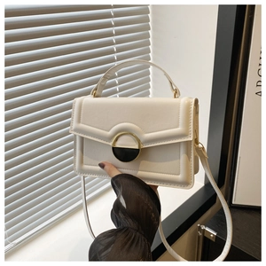 Detail of white leather crossbody bag with vintage metal buckle and top handle