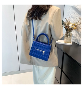 Blue quilted crossbody bag shown on model highlighting the size and shoulder strap