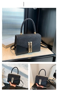 Close-up of black leather handbag with glitter patchwork and gold H-shaped buckle detail