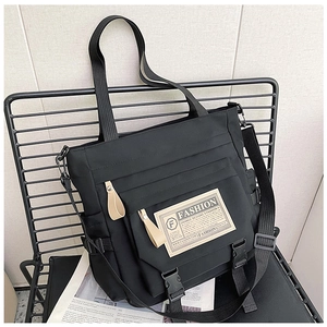 Dettaglio di borsa messenger in nylon con patch fashion e tracolla regolabile