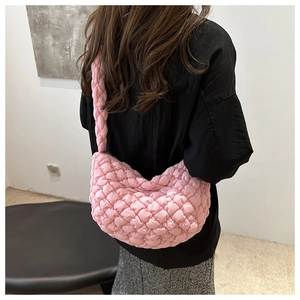 Détail de la texture matelassée rose du sac nuage porté par un mannequin