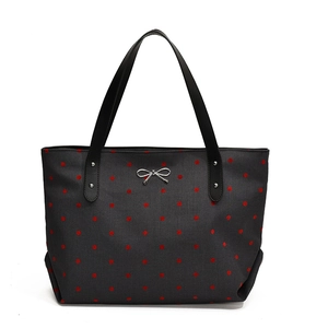 Black canvas tote bag with red polka dots and a silver metal bow charm for women