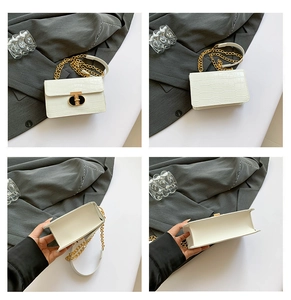 Detail view of white croc-embossed small square bag with gold chain and hardware