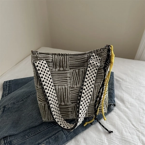 Large taupe geometric canvas tote bag with checkered strap on casual denim background