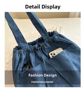 Close-up of denim tote bag showing drawstring closure and functional side pockets