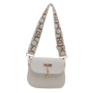 Minimalist beige crossbody bag with deer charm and patterned wide strap in front view