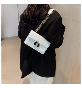 Detail of white crocodile pattern square bag with gold chain and metal buckle