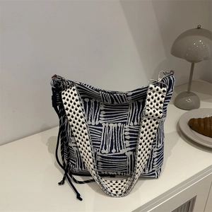 Large blue and white woven canvas tote bag with geometric pattern and tassel detail