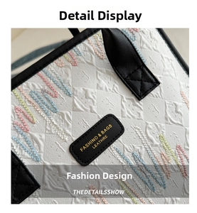 Detail of white tote with colorful wave embroidery and black leather logo patch