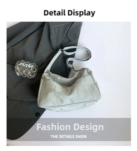 Detail view of mint green textured nylon crescent bag with adjustable strap on blazer