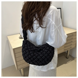 Vue détaillée du sac nuage plissé noir porté par un mannequin sur une chemise blanche