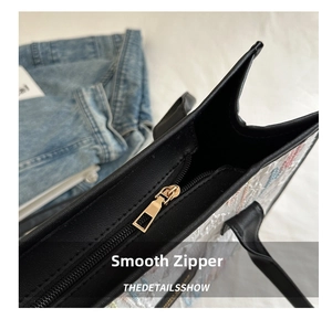 Detail of high-quality smooth gold metal zipper on a colorful embroidered tote bag
