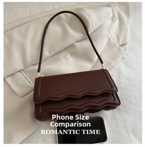Detailansicht der dunkelbraunen Vintage-Tasche mit Smartphone für den Größenvergleich