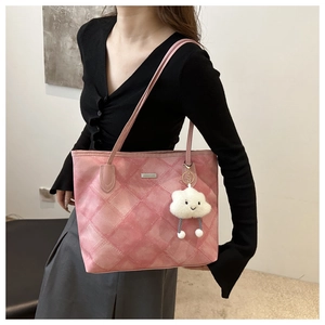 Pink quilted tote bag for women with cloud charm accessory shown on model shoulder