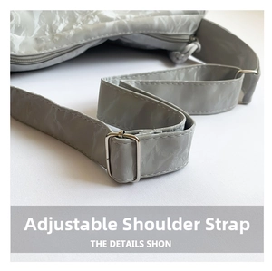 Detail of adjustable gray glossy pleated shoulder strap with silver metal buckle