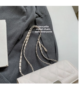 Close-up of quilted diamond pattern with woven hardware chain strap and metal lock