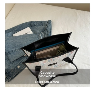 Top view of spacious white tote bag interior with books and tablet in lifestyle setting