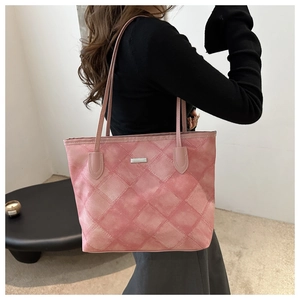 Close-up of pink quilted tote bag showing rhombus stitching and metal logo plate