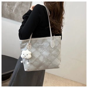 Detailed side view of grey quilted tote bag with white cloud plush charm for daily commuting
