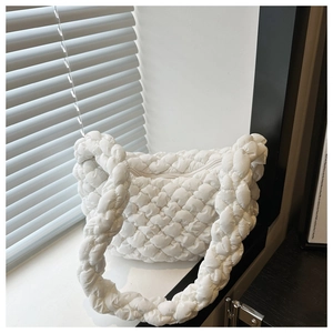 Gros plan sur la texture matelassée et la poignée rembourrée du sac nuage blanc