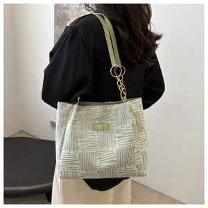 Retro green plaid tote bag with woven texture worn by model in a minimalist setting