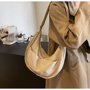 Détail du sac bandoulière croissant en nylon beige avec poches et style urbain
